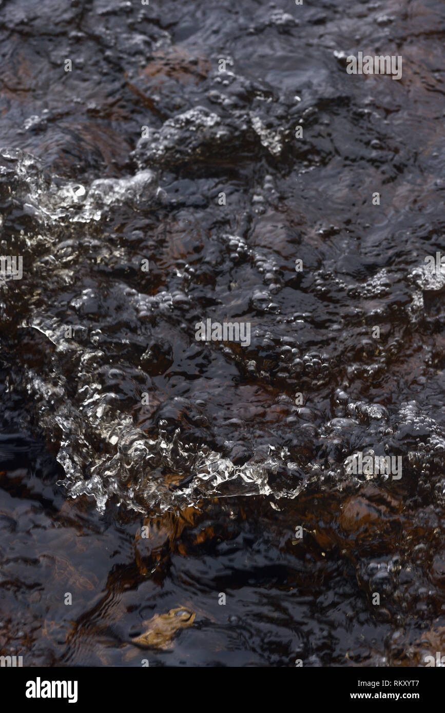 A raging stream of water in a swift stream. Stock Photo