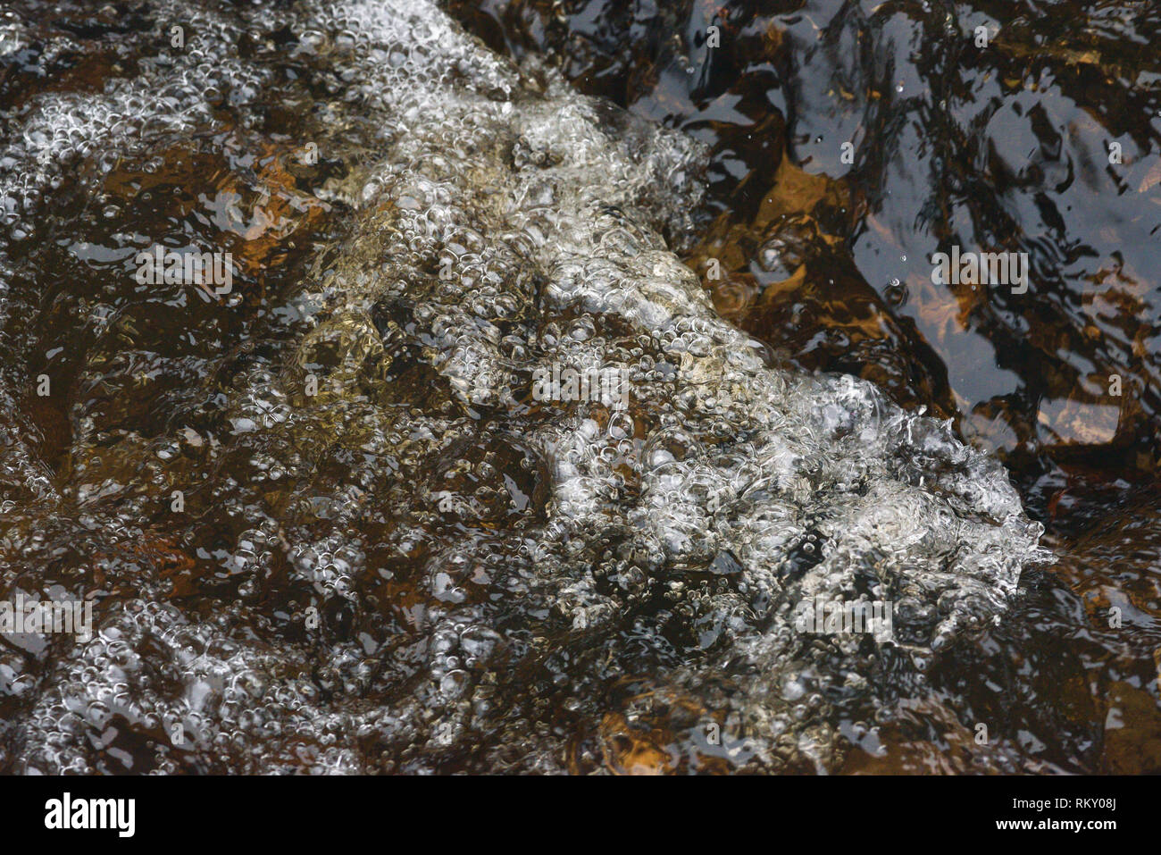 A raging stream of water in a swift stream. Stock Photo