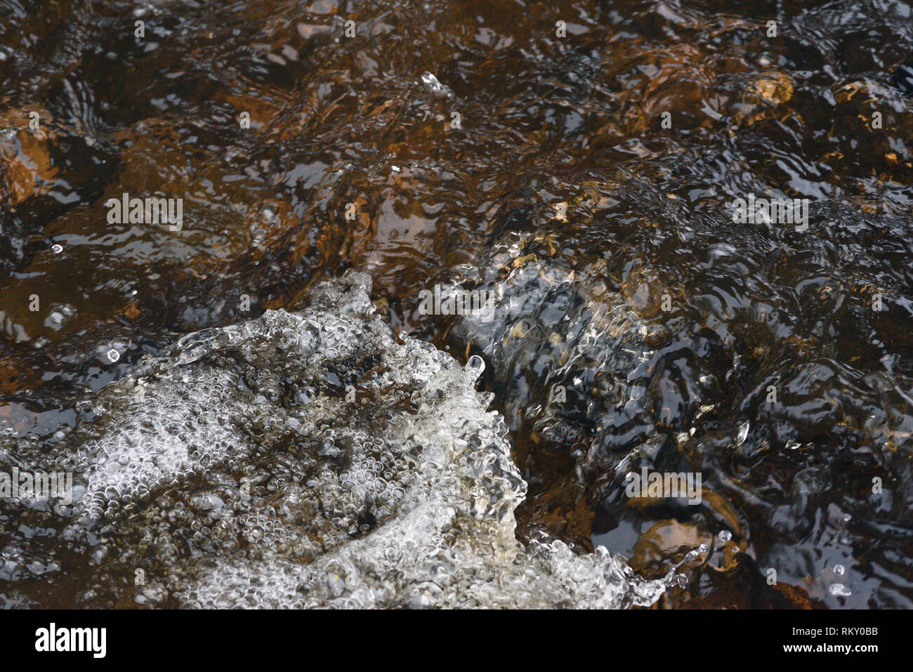 A raging stream of water in a swift stream. Stock Photo