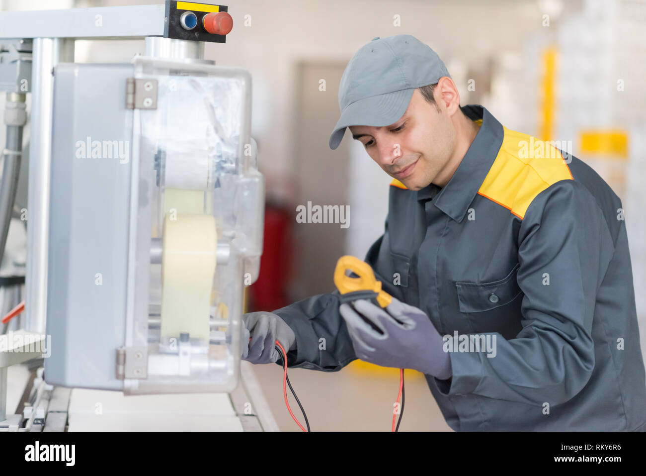 Industrial electrician fixing a machine Stock Photo
