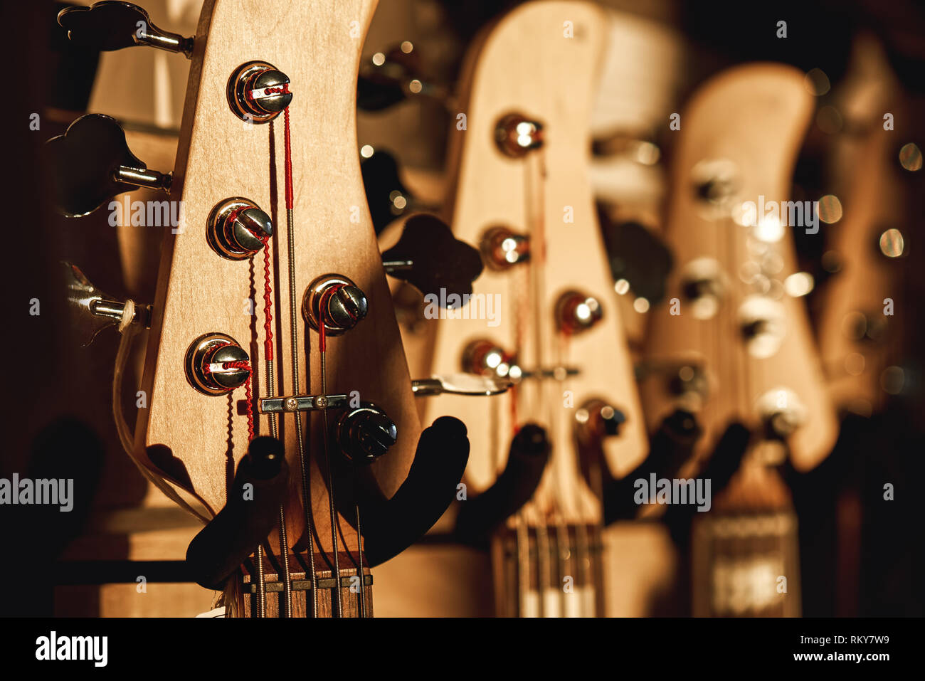 Uppermost part of the guitar. Close view of several acoustic guitar headstocks with tuning keys for ajusting guitar strings. Music shop. Musical instrument. Live music Stock Photo