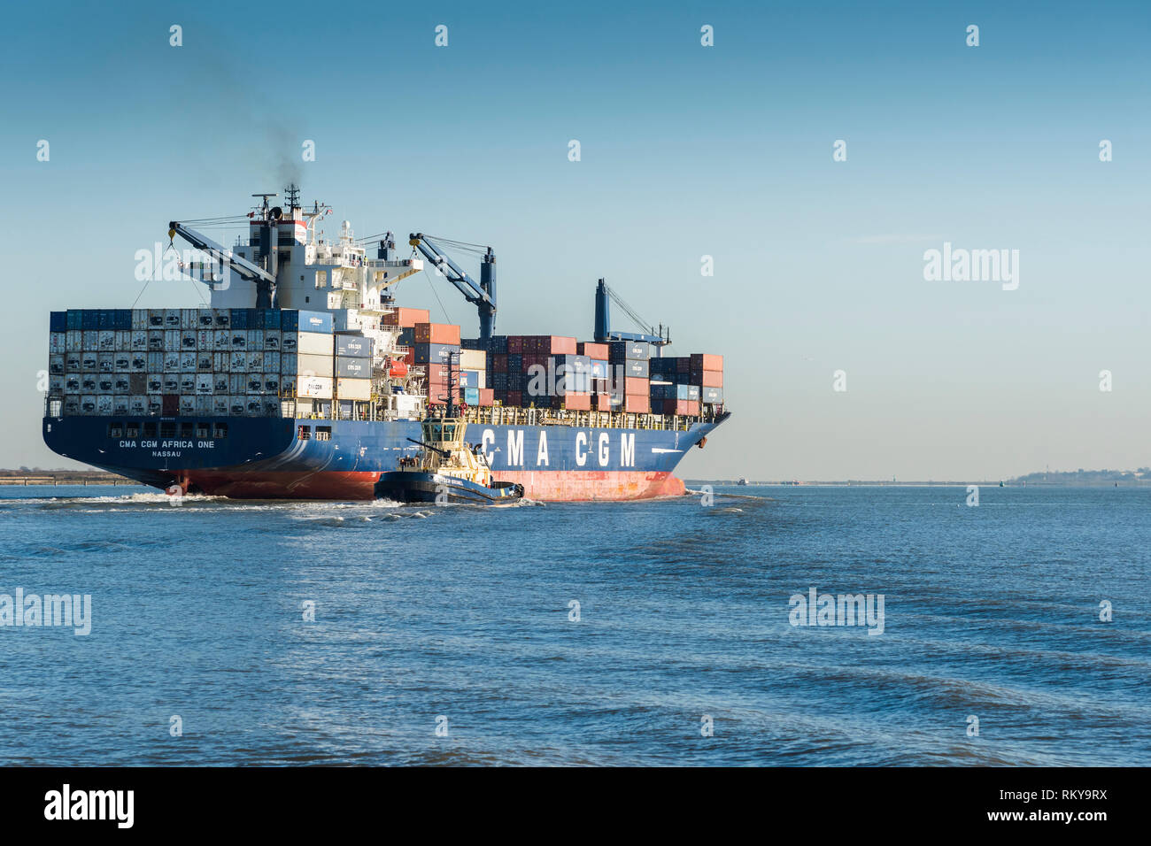 The Africa One container ship leaving the Port of Tilbury steaming downriver on the River Thames. Stock Photo