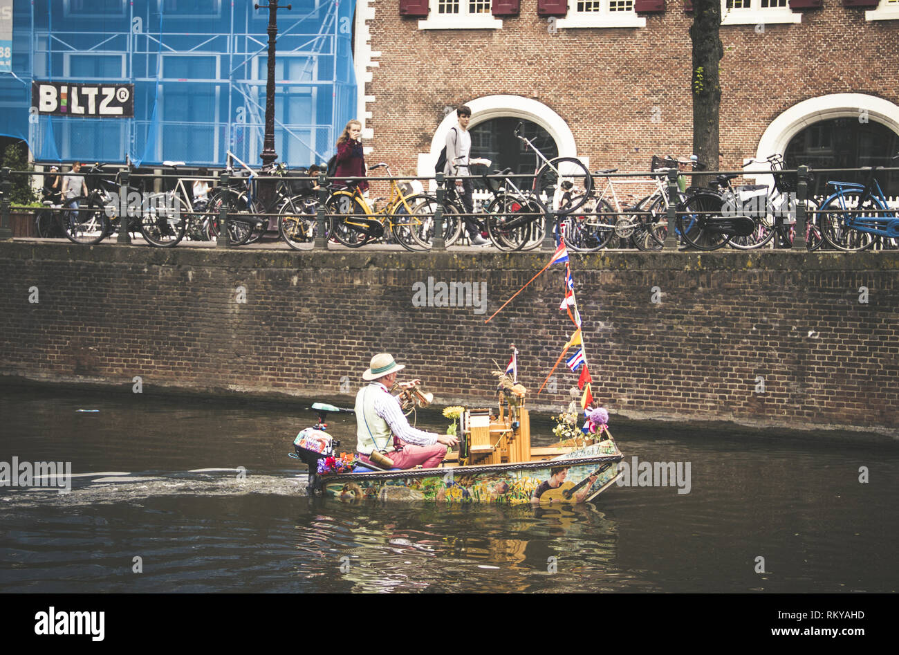 Man in colorful painted boat plays the trumpet. Stock Photo