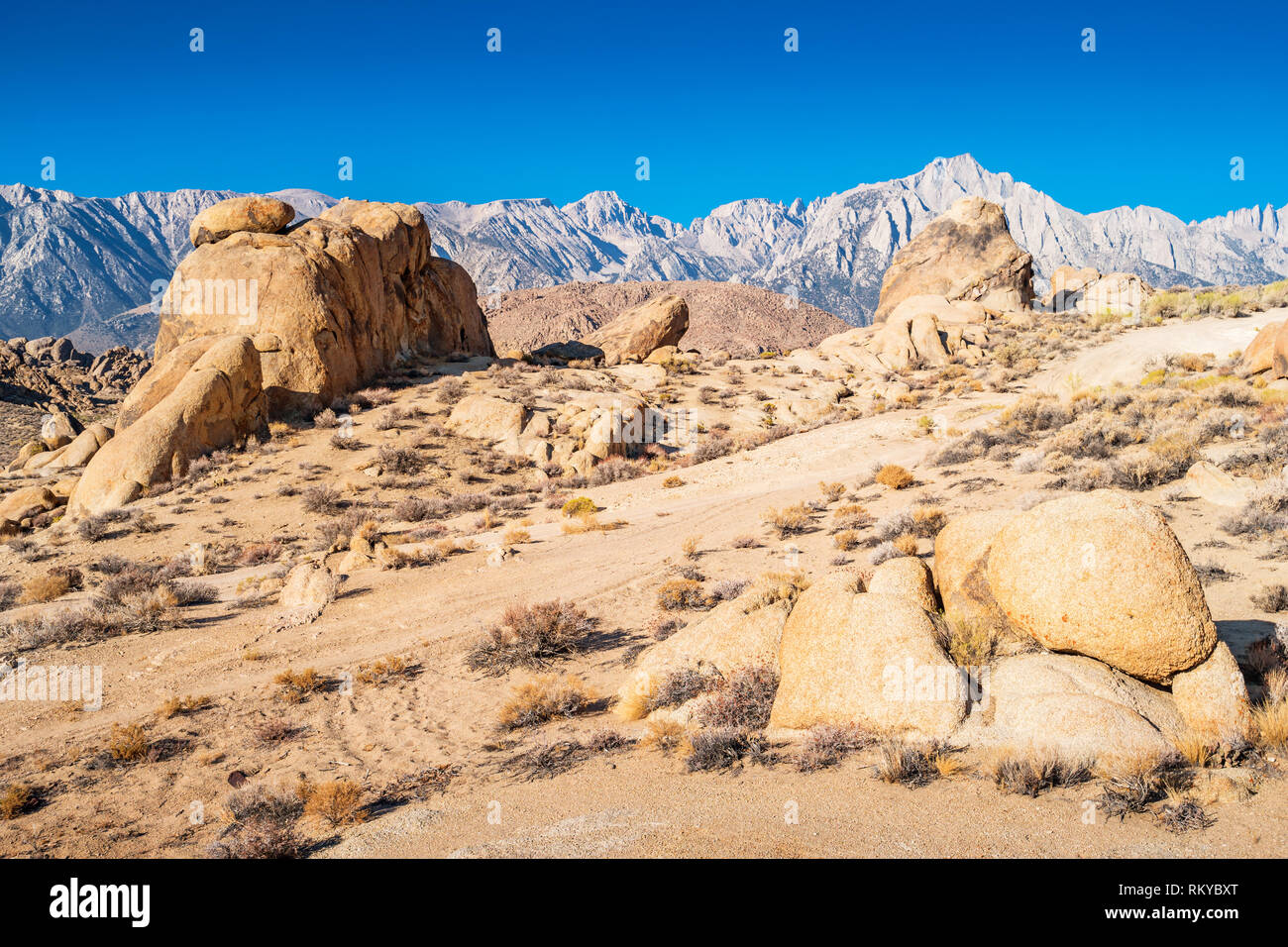 Dirt road leads through rock formations in the Alabama Hills, Lone Pine, California, USA. Stock Photo
