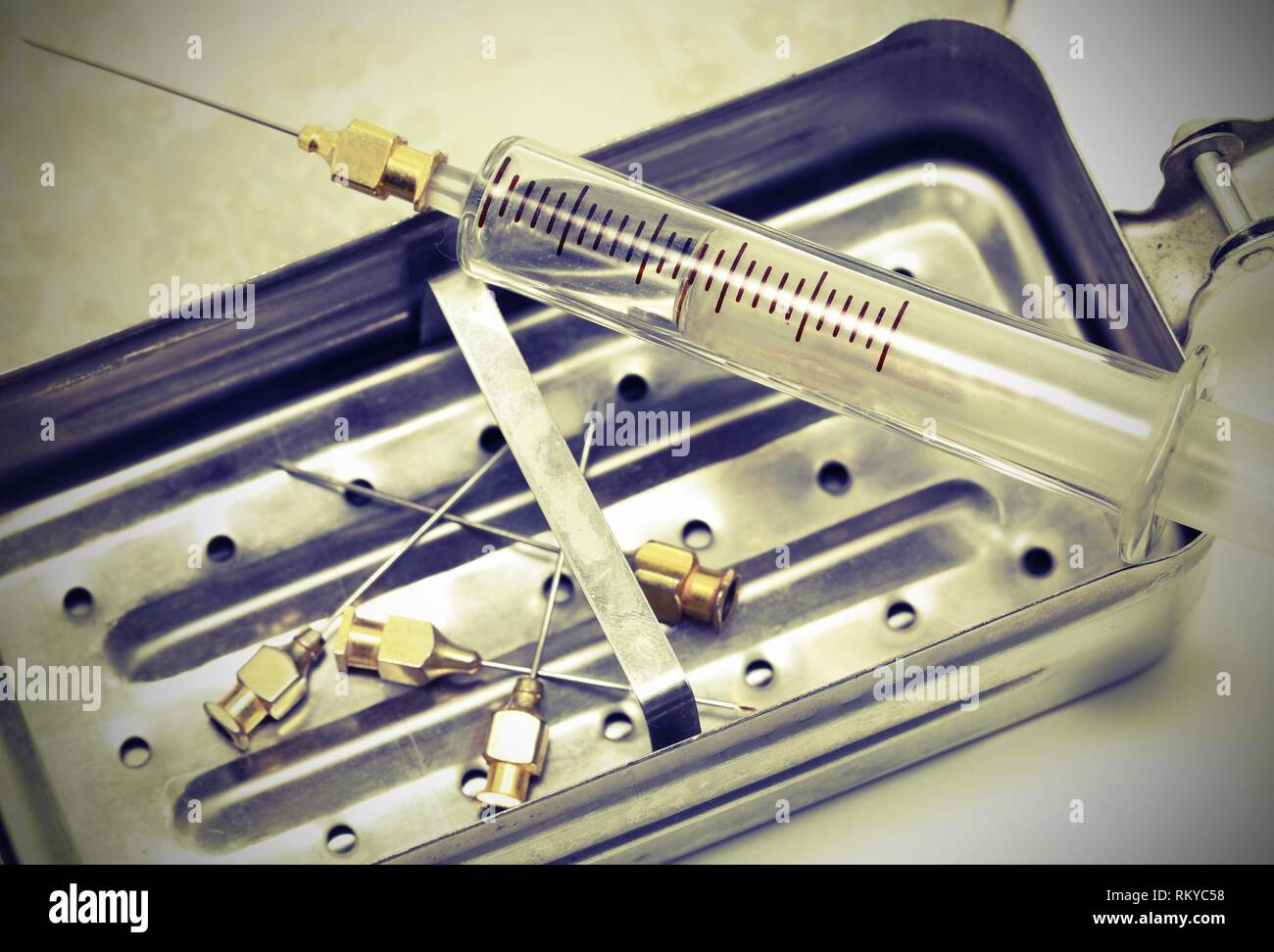 old syringe in glass and many neddles with vintage toned effect Stock Photo