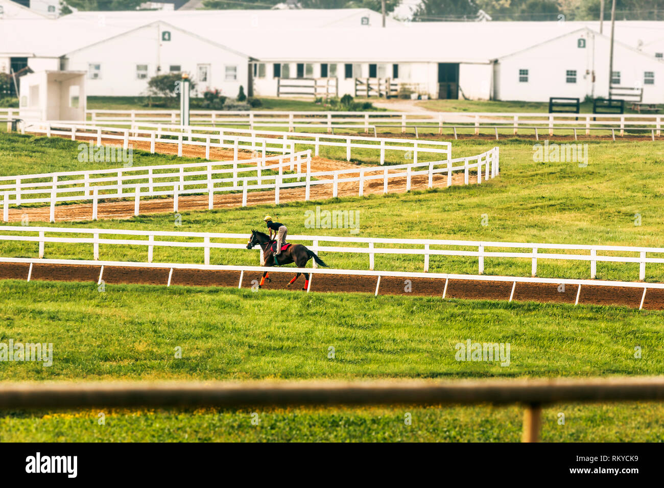 Jockey riding a race horse during workouts on a practice dirt track on