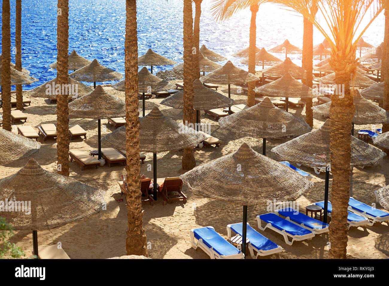 Summer chaise lounges under an umbrella on sandy sea beach in hotel Egypt, Sharm el Sheikh, concept time to travel Stock Photo