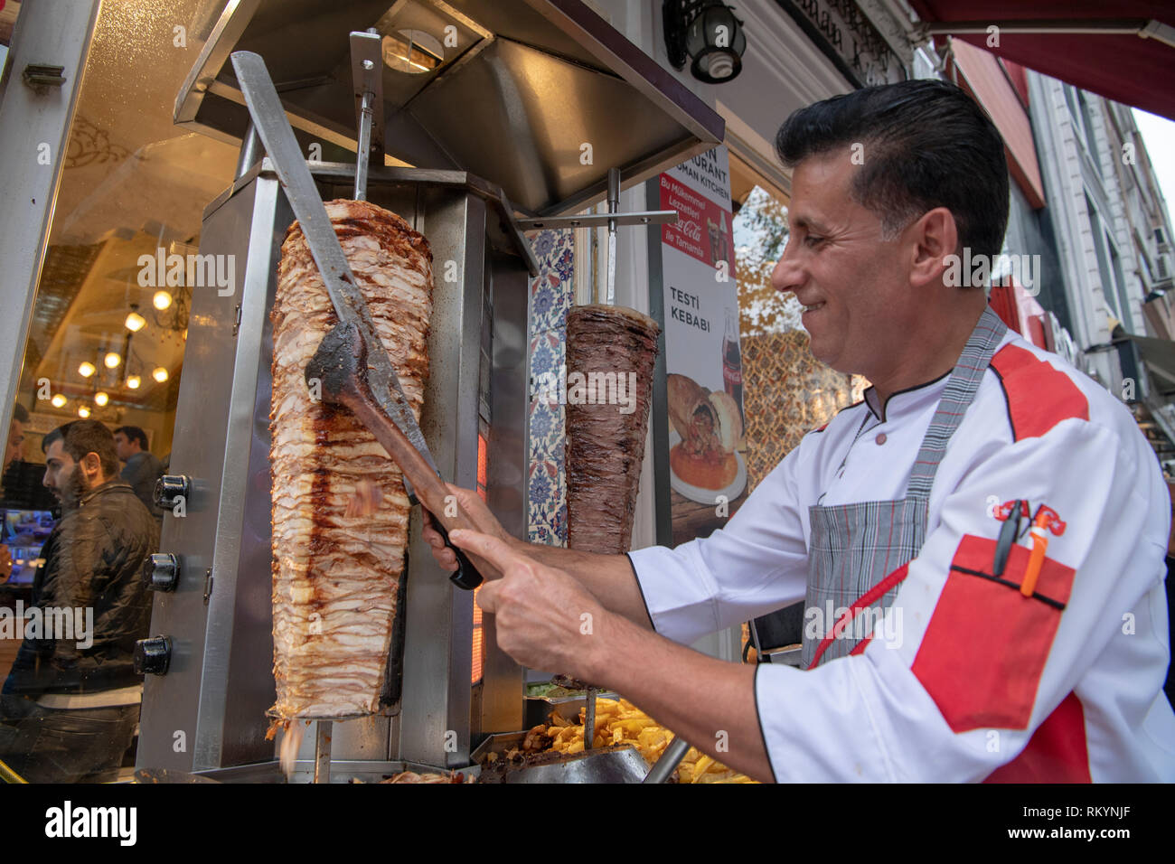 Chef cutting chicken kebab from a street food stall in Istanbul in