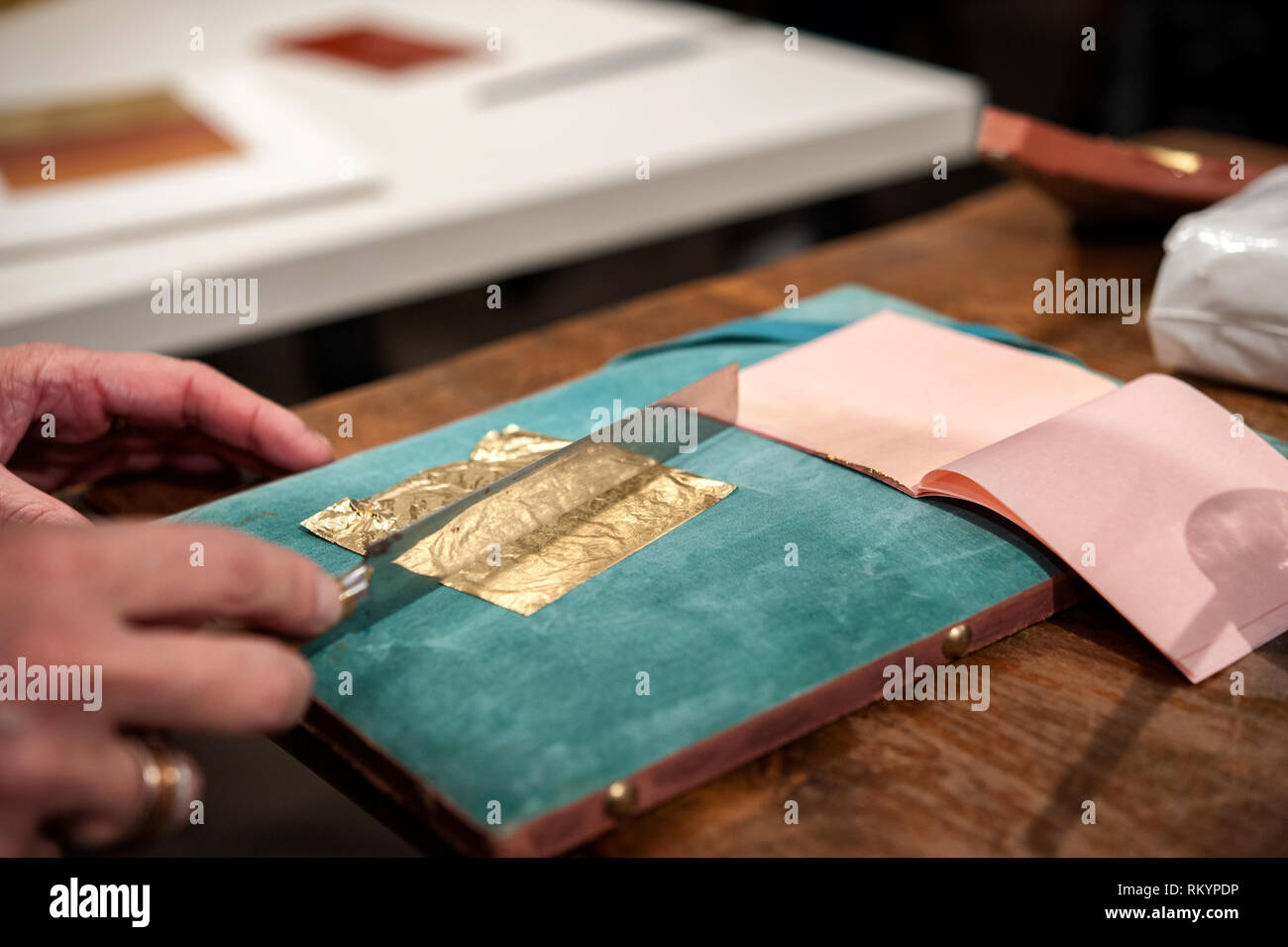 Craftsman cuts an extremely thin gold leaf for the gilding tecnique. Stock Photo