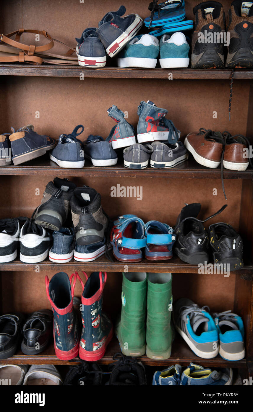 Childrens Shoes Stored In An Old Oak Bookcase Uk Stock Photo