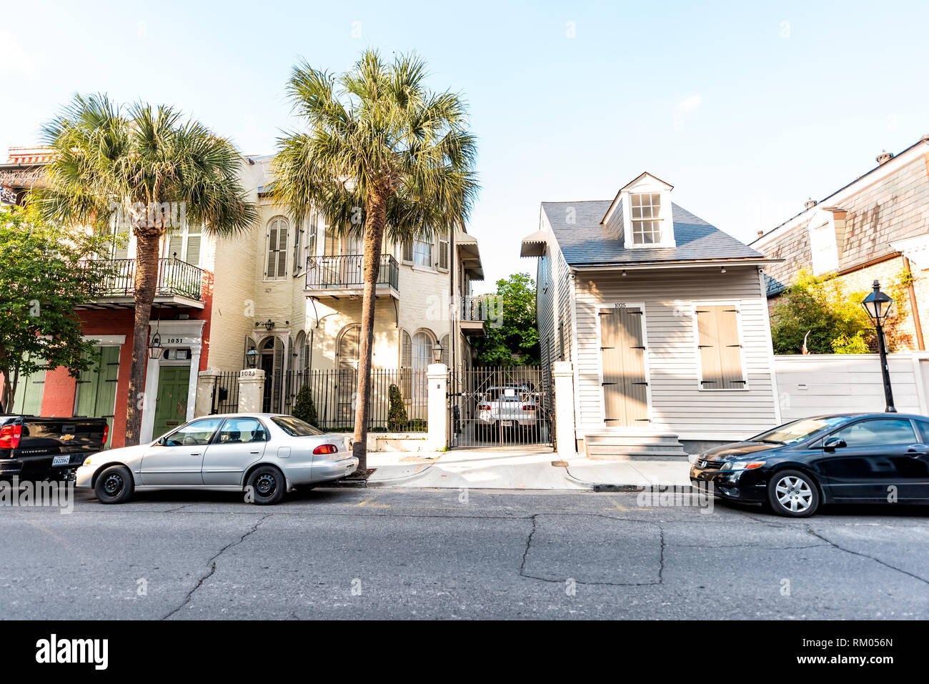 New Orleans, USA - April 23, 2018: Old town street in Louisiana famous town city with small buildings homes houses apartments during sunny day with ca Stock Photo