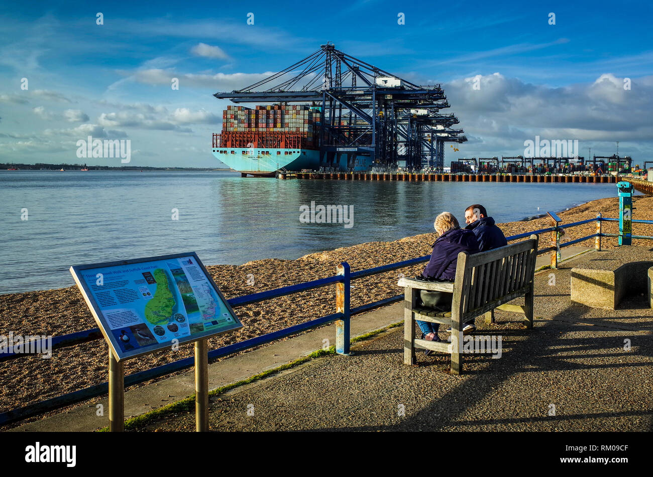 Port of Felixstowe - two people watch shipping containers being loaded and unloaded onto ships at Felixstowe Port, the UK's largest container port. Stock Photo