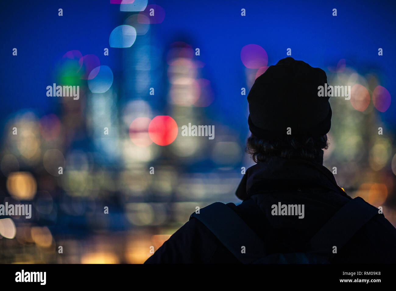 City of London Night Lights - a visitor views the lights of the City of London financial district from the Tate Modern Viewing Deck. London Bokeh. Stock Photo