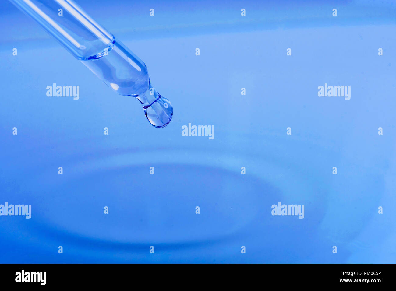 waterdrop with little waves from a pipette Stock Photo
