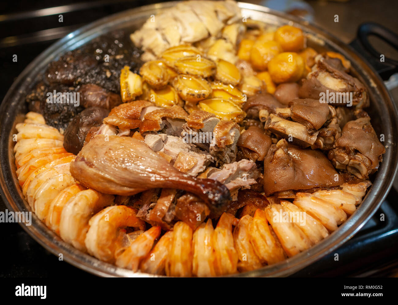 Traditional Chinese New Year cuisine known as Poon Choi, literally translated as big bowl feast, basin cuisine or Chinese casserole. Originated in Hon Stock Photo