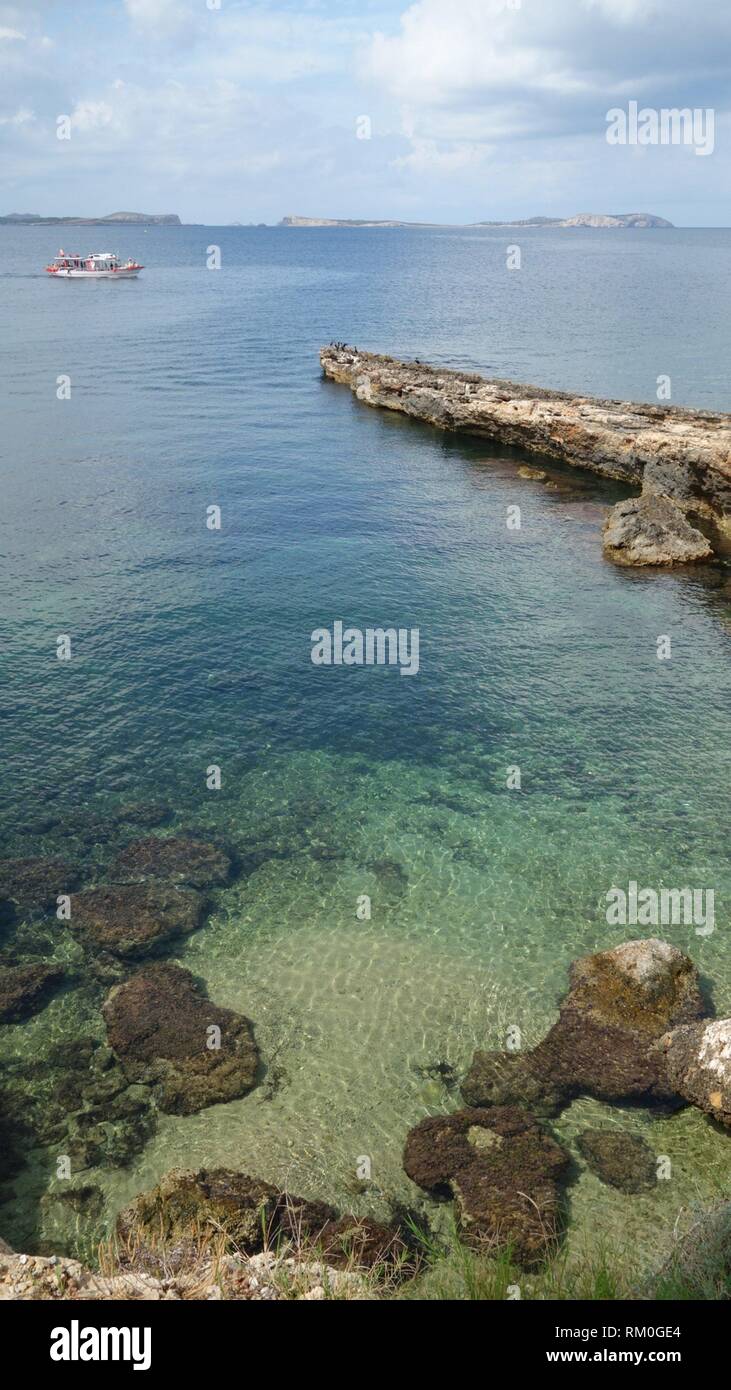 Rock beach in the balearic town of Sant Antoni de Portmany, in the island of Ibiza, Spain, Europe. Stock Photo