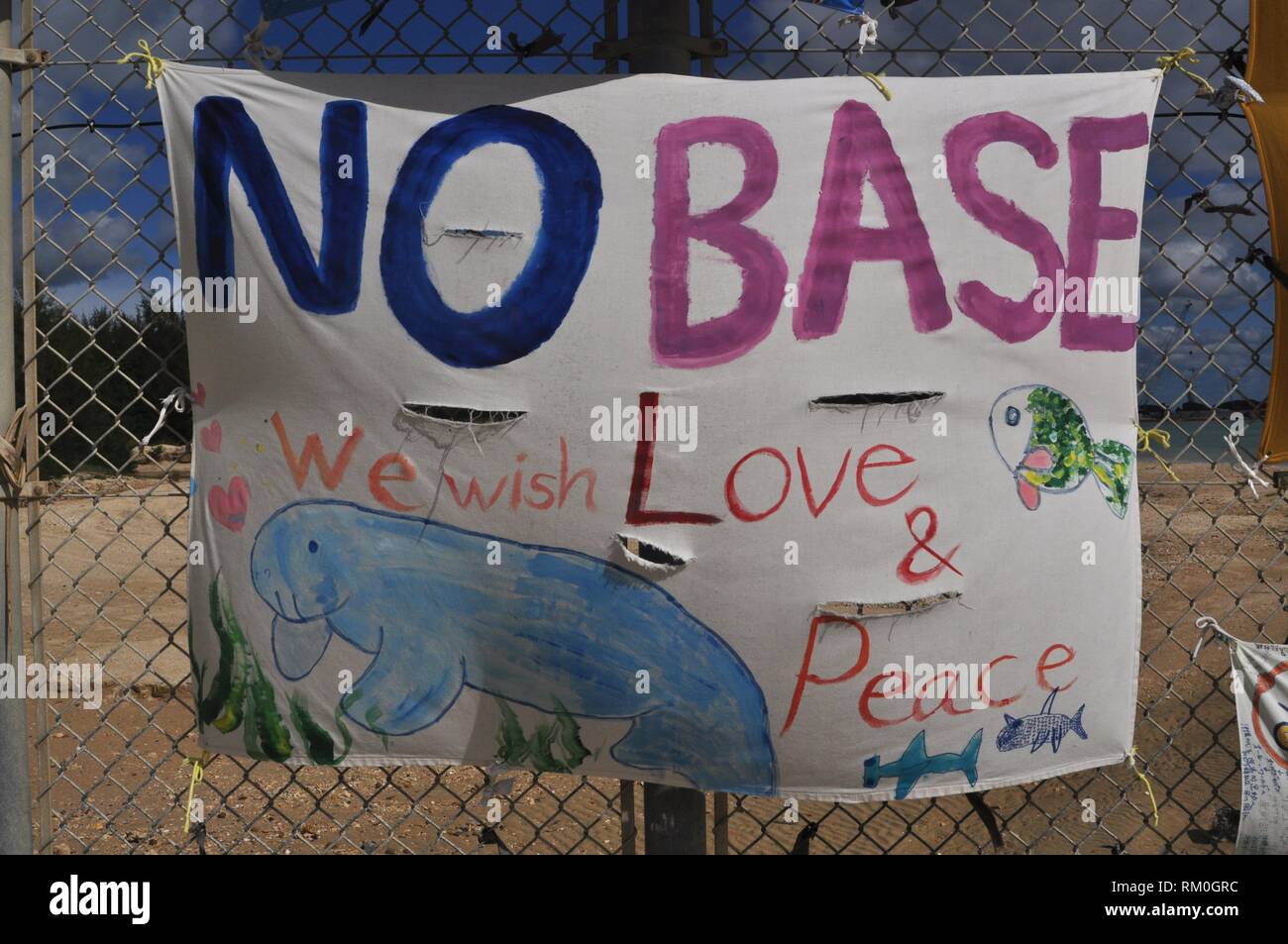 Henoko Bay, Okinawa, Japan: sign for peace along the fence of American Marines military base of Camp Schwab Stock Photo