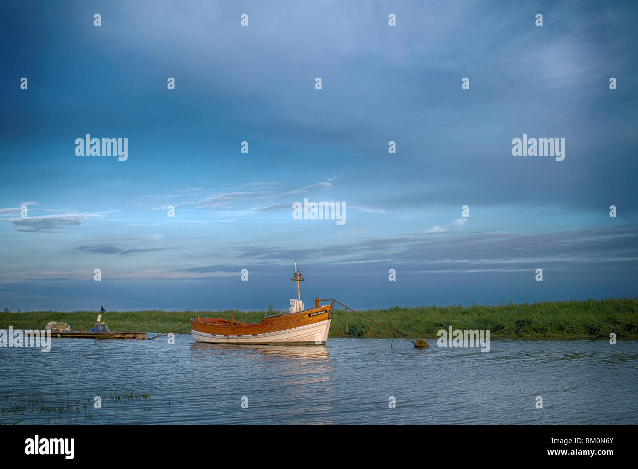Wooden fishing boat moored in the river with setting sun Stock Photo ...