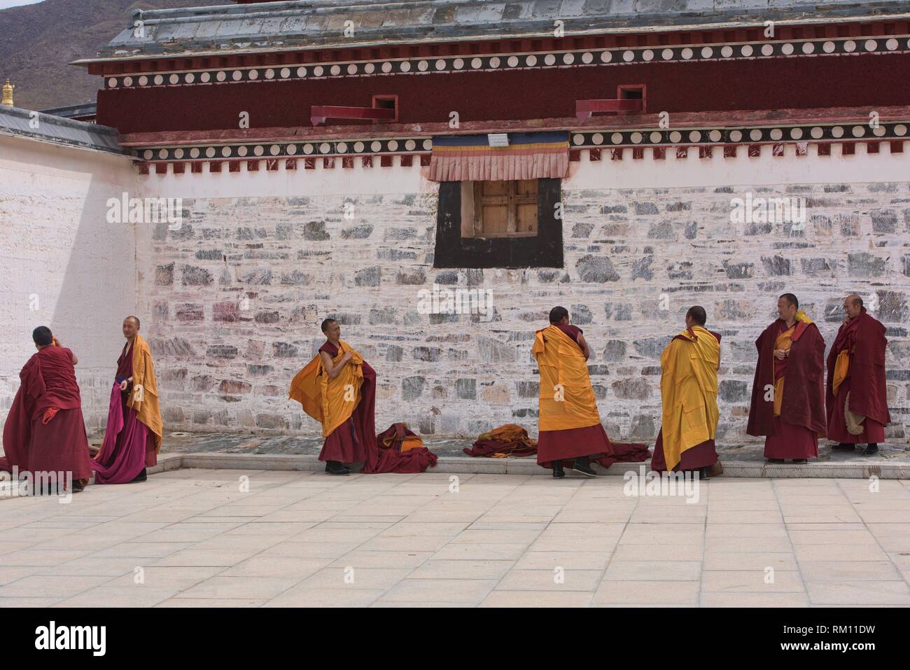Gelukpa monks putting on their robes, Labrang Monastery, Xiahe, Gansu, China. Stock Photo
