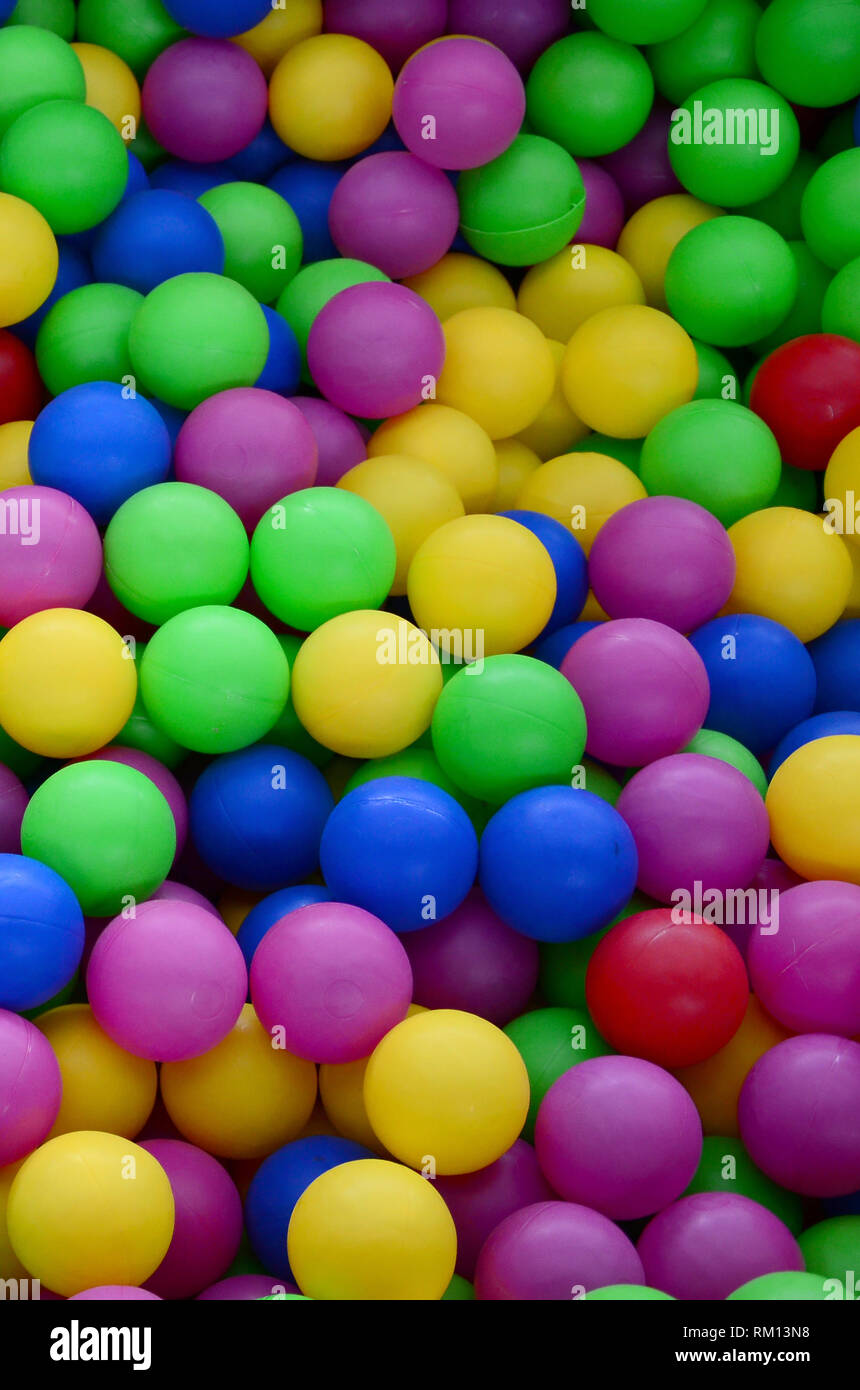 Colored plastic balls in pool of game room. Swimming pool for fun and jumping in colored plastic