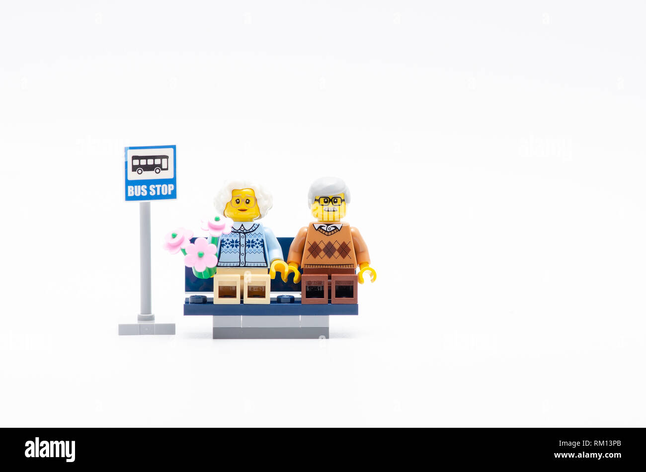 senior man and women with flower sitting waiting a bus. Lego minifigures  are manufactured by The Lego Stock Photo - Alamy