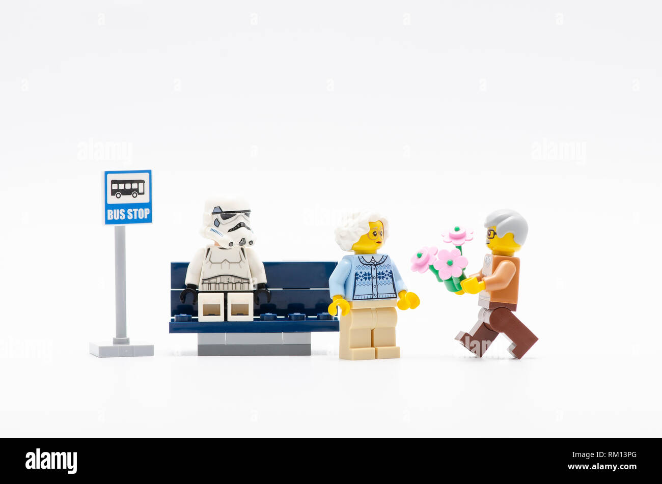 storm trooper watching senior man with flower walking to  a senior women .  Lego minifigures are manufactured by The Lego. Stock Photo