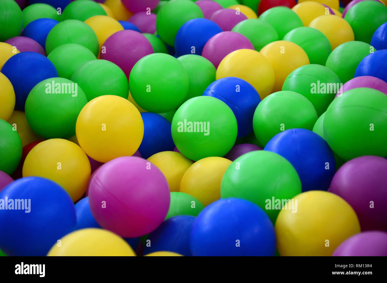 Colored plastic balls in pool of game room. Swimming pool for fun and ...