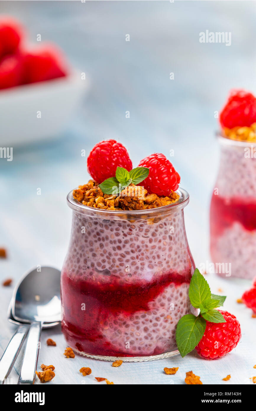 Served glass jars filled with delicious chia pudding with raspberry and