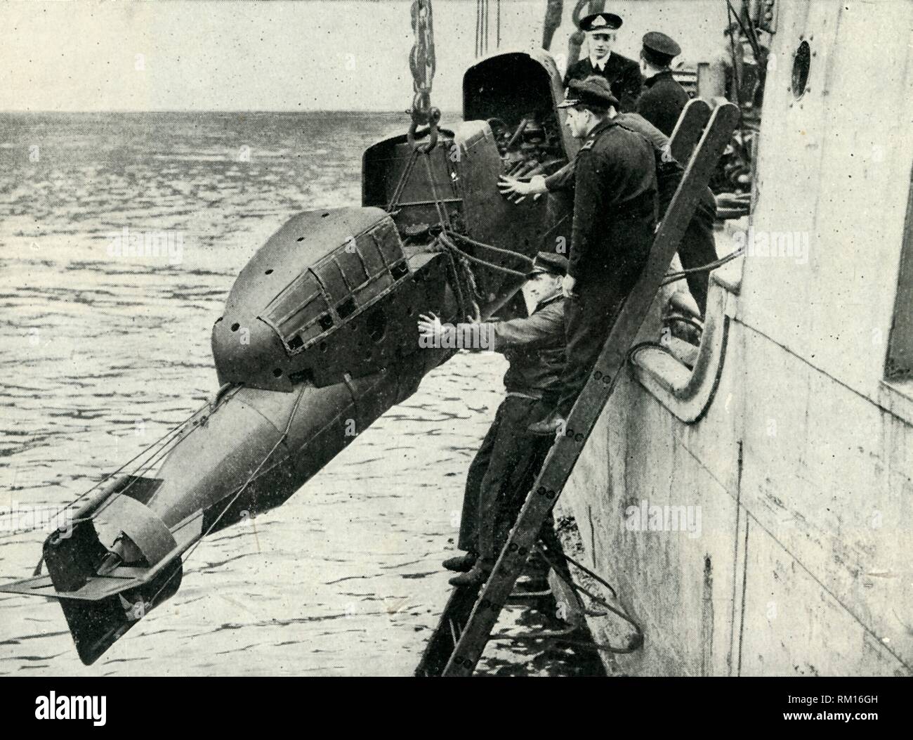 Hoisting a Chariot manned torpedo on board a ship, World War II, 1945. Creator: Unknown. Stock Photo