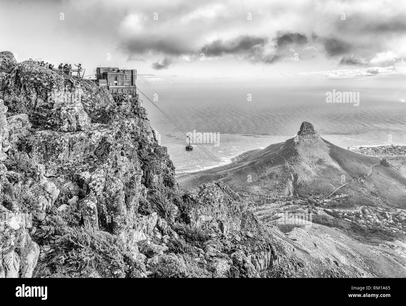 CAPE TOWN, SOUTH AFRICA, AUGUST 17, 2018: View from the top of Table mountain in Cape Town. The upper cable station, a cable car, tourists and Lions H Stock Photo