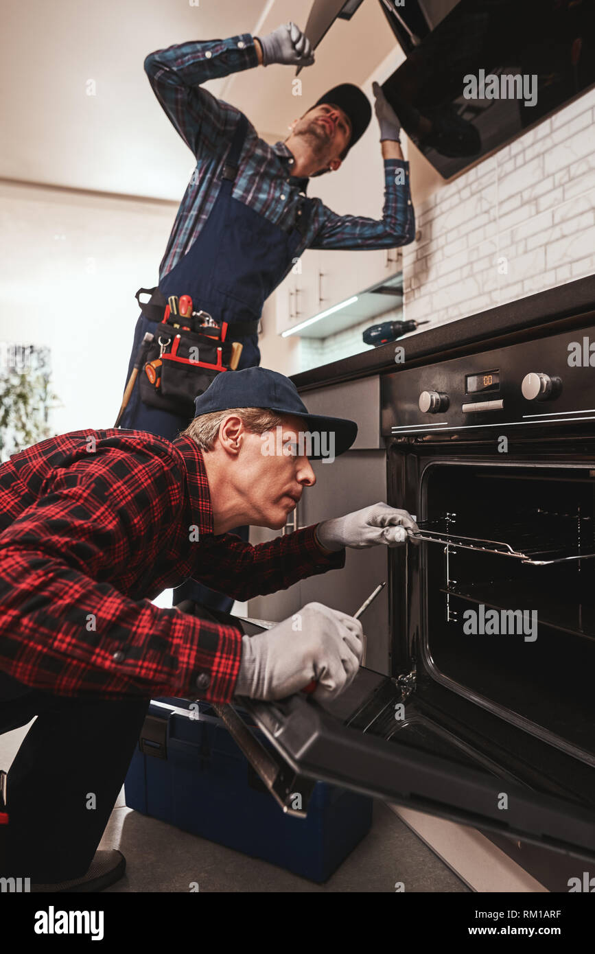 Productive together. Photo of two mechanics working at the kitchen ...