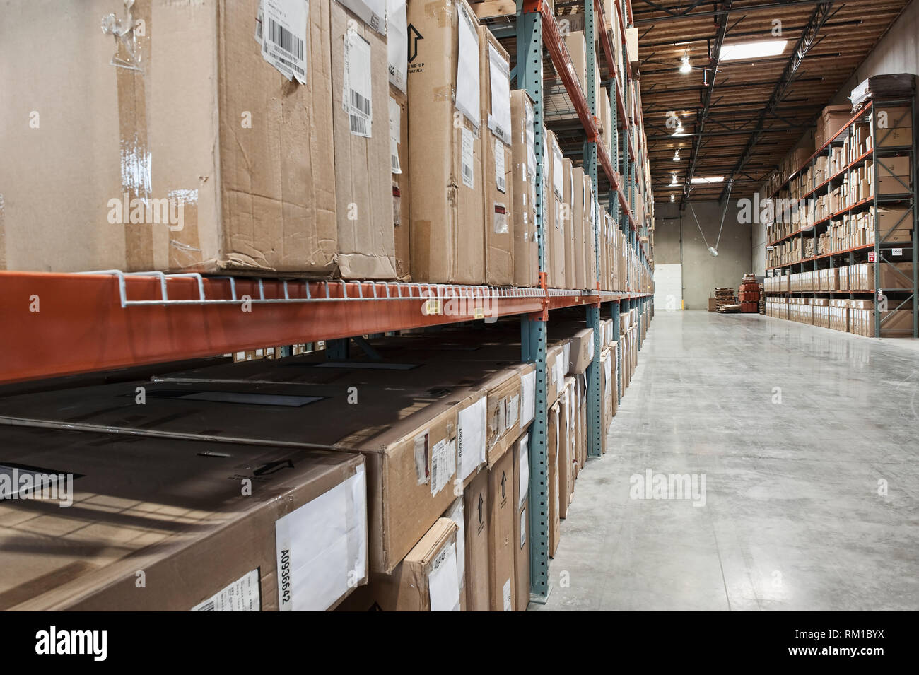 Cardboard boxes on shelves in warehouse Stock Photo - Alamy