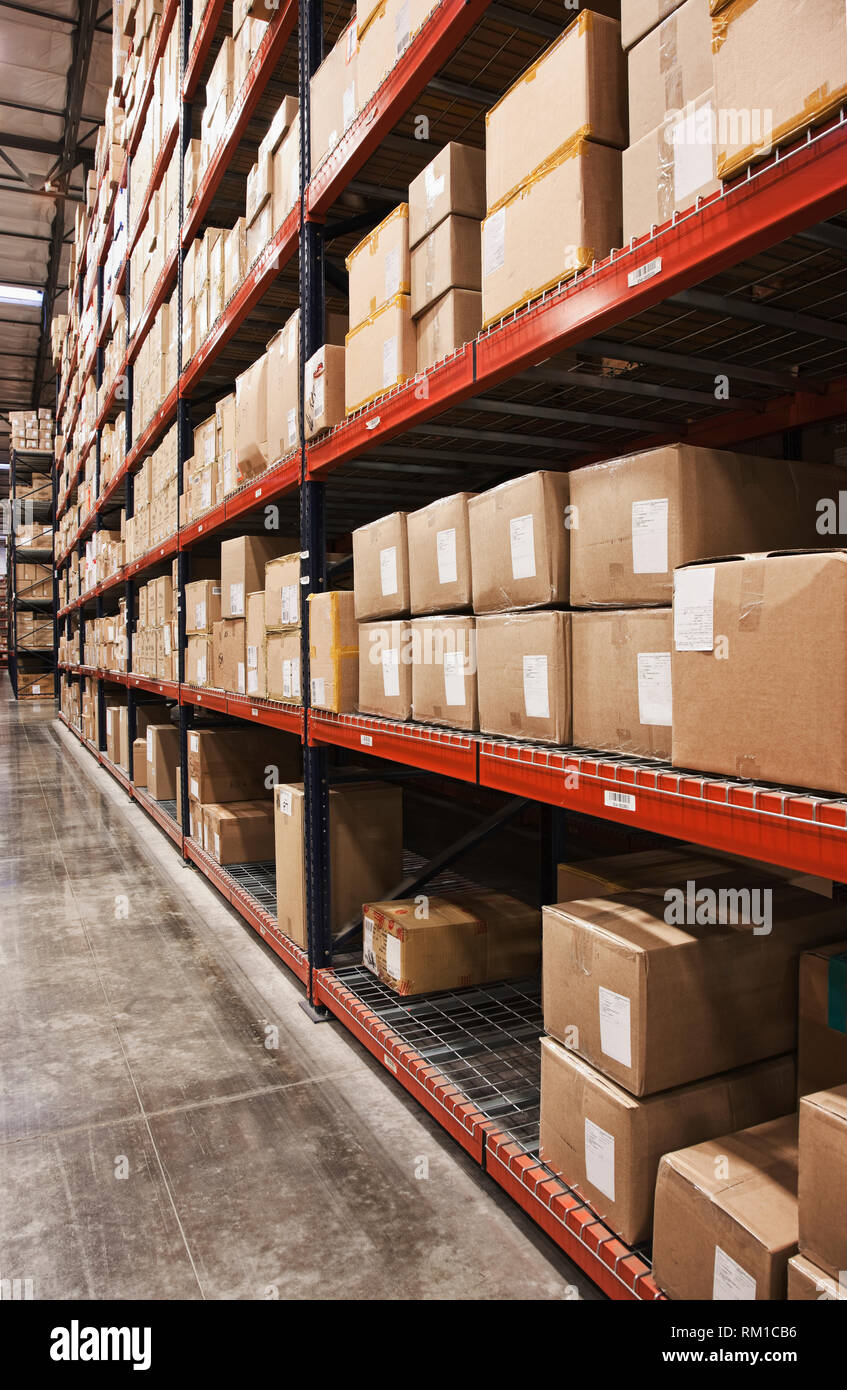 Cardboard boxes on shelves in warehouse Stock Photo - Alamy