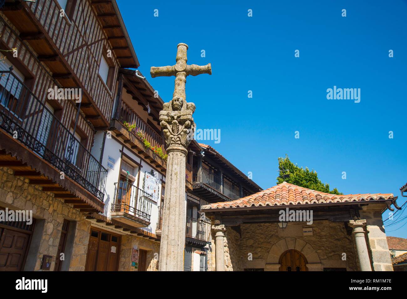 Stone cross and facades of houses. Mogarraz, Sierra de Francia