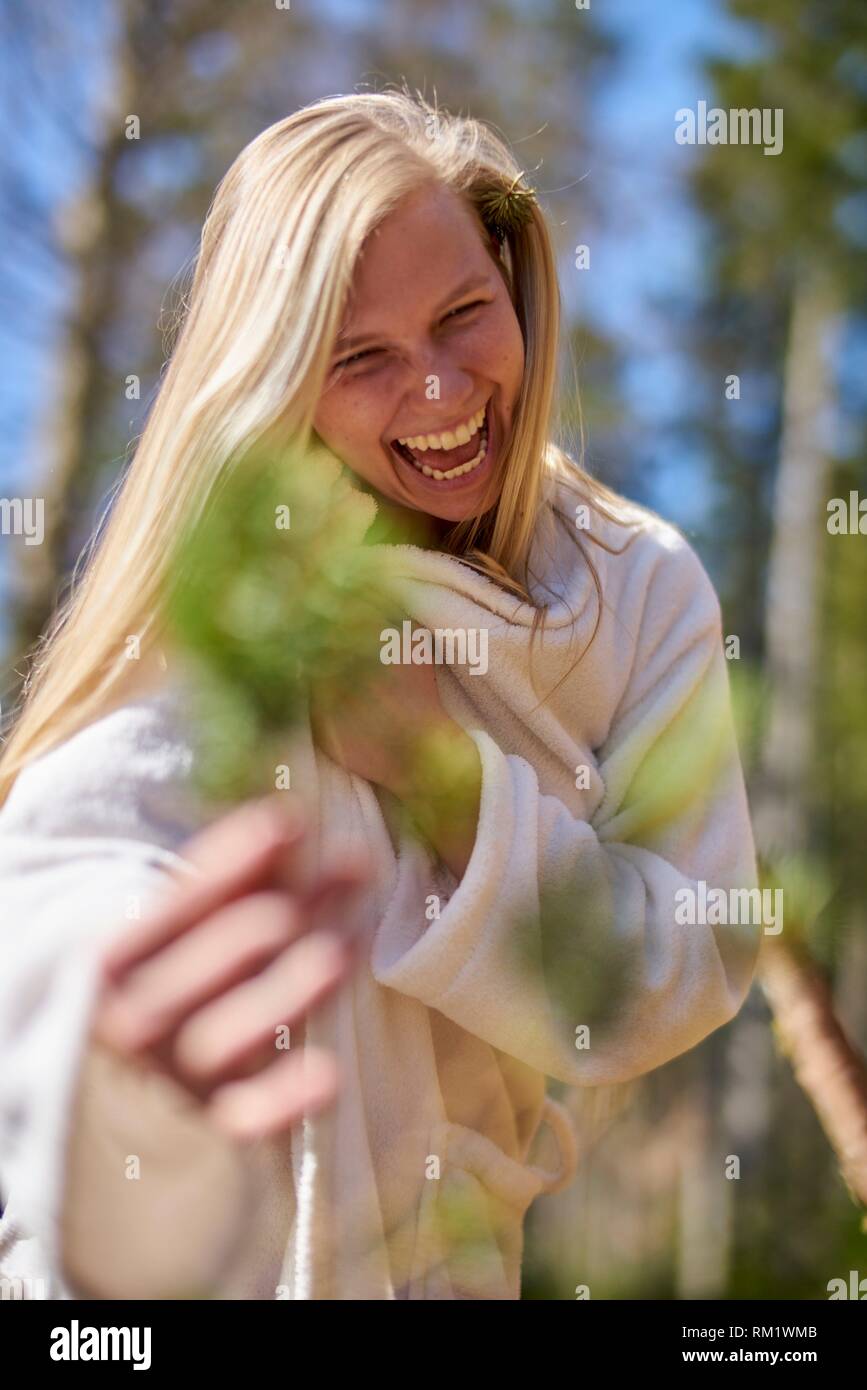 Portrait of woman in nature wearing a white bathrobe, holding a branch. Waakirchen, Bavaria