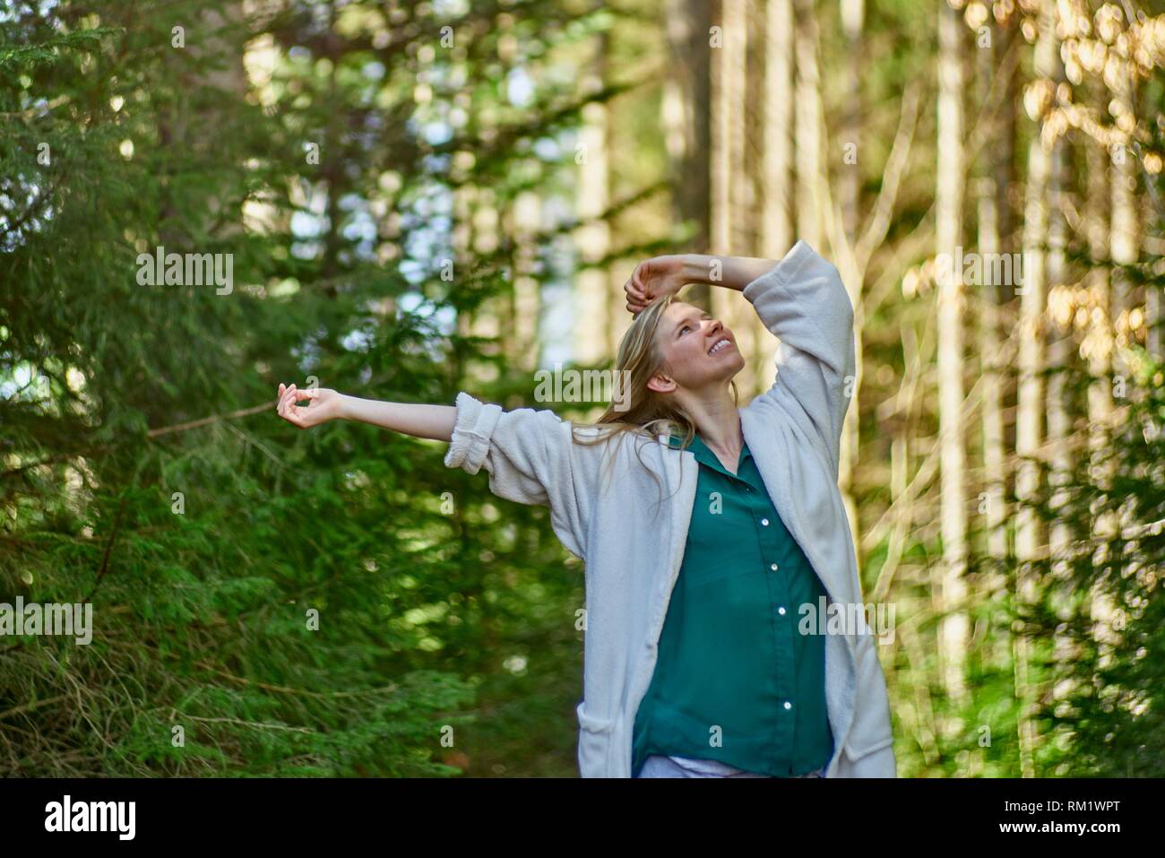 Portrait of woman in nature wearing a white bathrobe. Waakirchen, Bavaria, Germany Stock Photo
