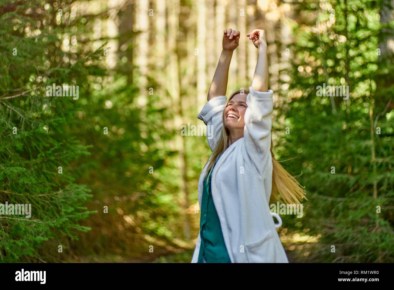 Portrait of woman in nature wearing a white bathrobe. Waakirchen, Bavaria, Germany Stock Photo