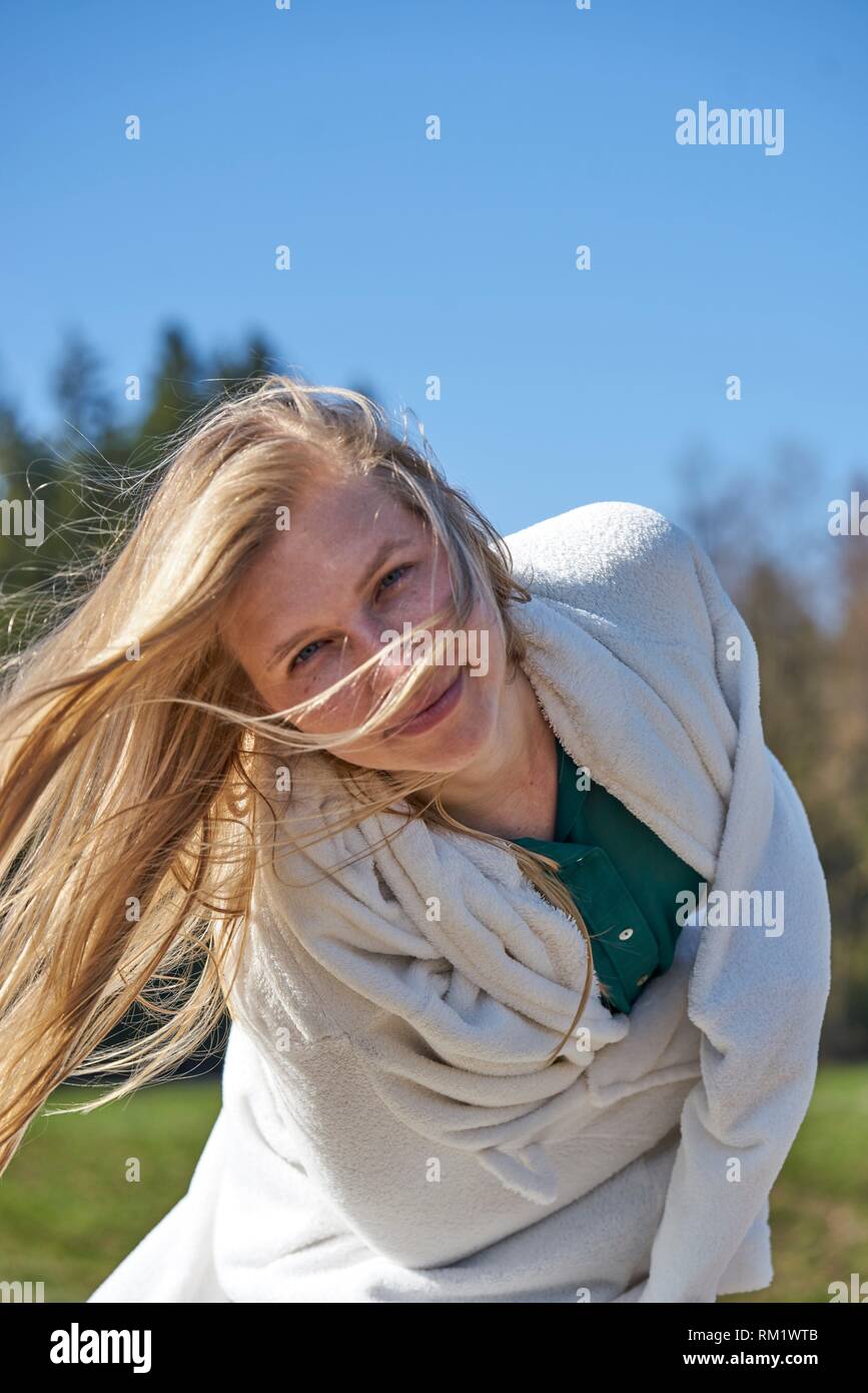Portrait of woman in nature wearing a white bathrobe. Waakirchen, Bavaria, Germany Stock Photo