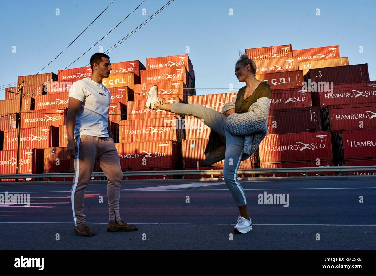Australia, Adelaide, woman kicking food to man, in front of ship