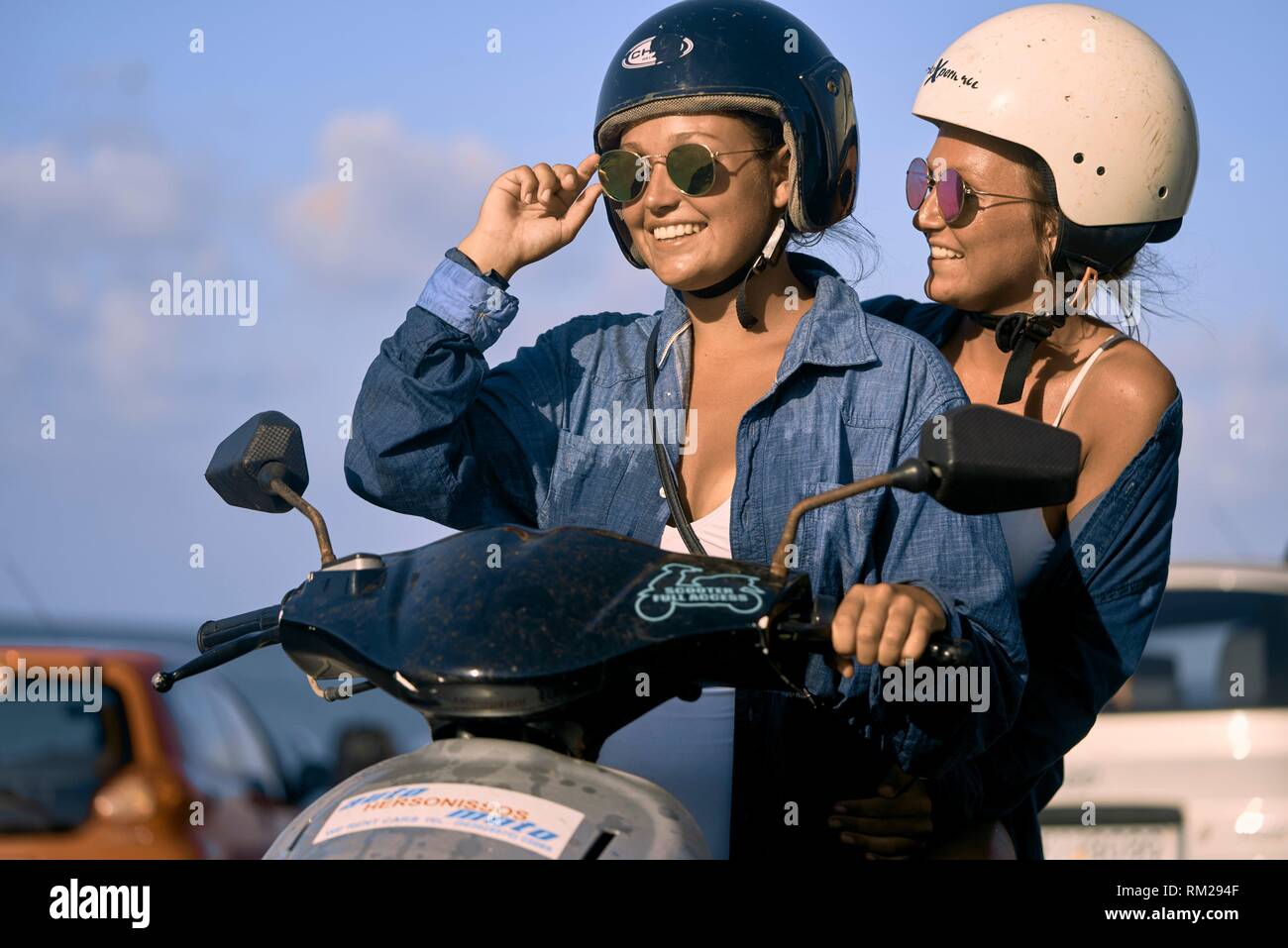Two women driving scooter, Chersonissos, Crete, Greece Stock Photo Alamy