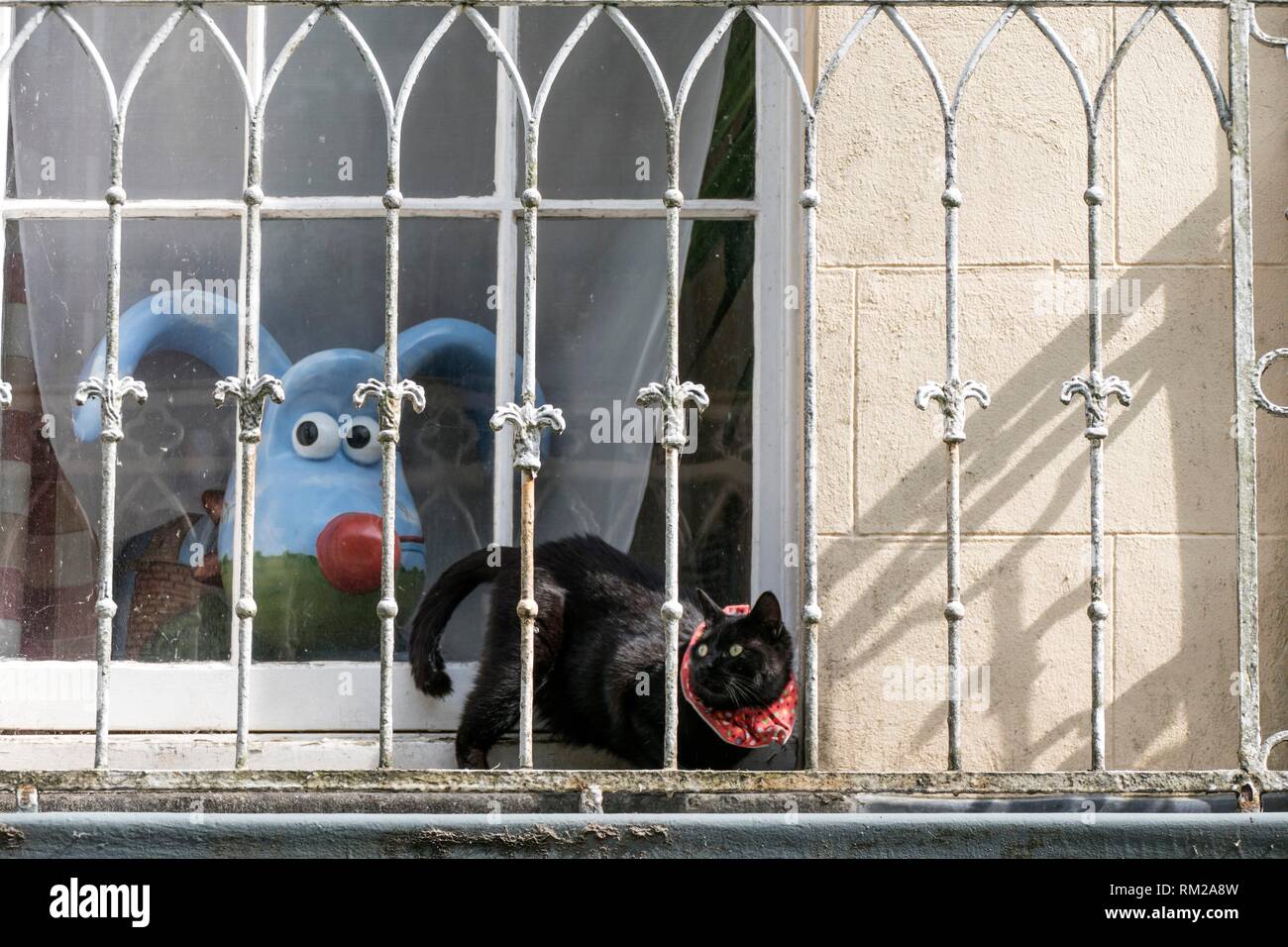Nick Park´s Clifton High School gromit, ´Polygrom´, and Sparky the cat with loopy ears and tail and surprised eyes on a balcony in Bristol, England. Stock Photo