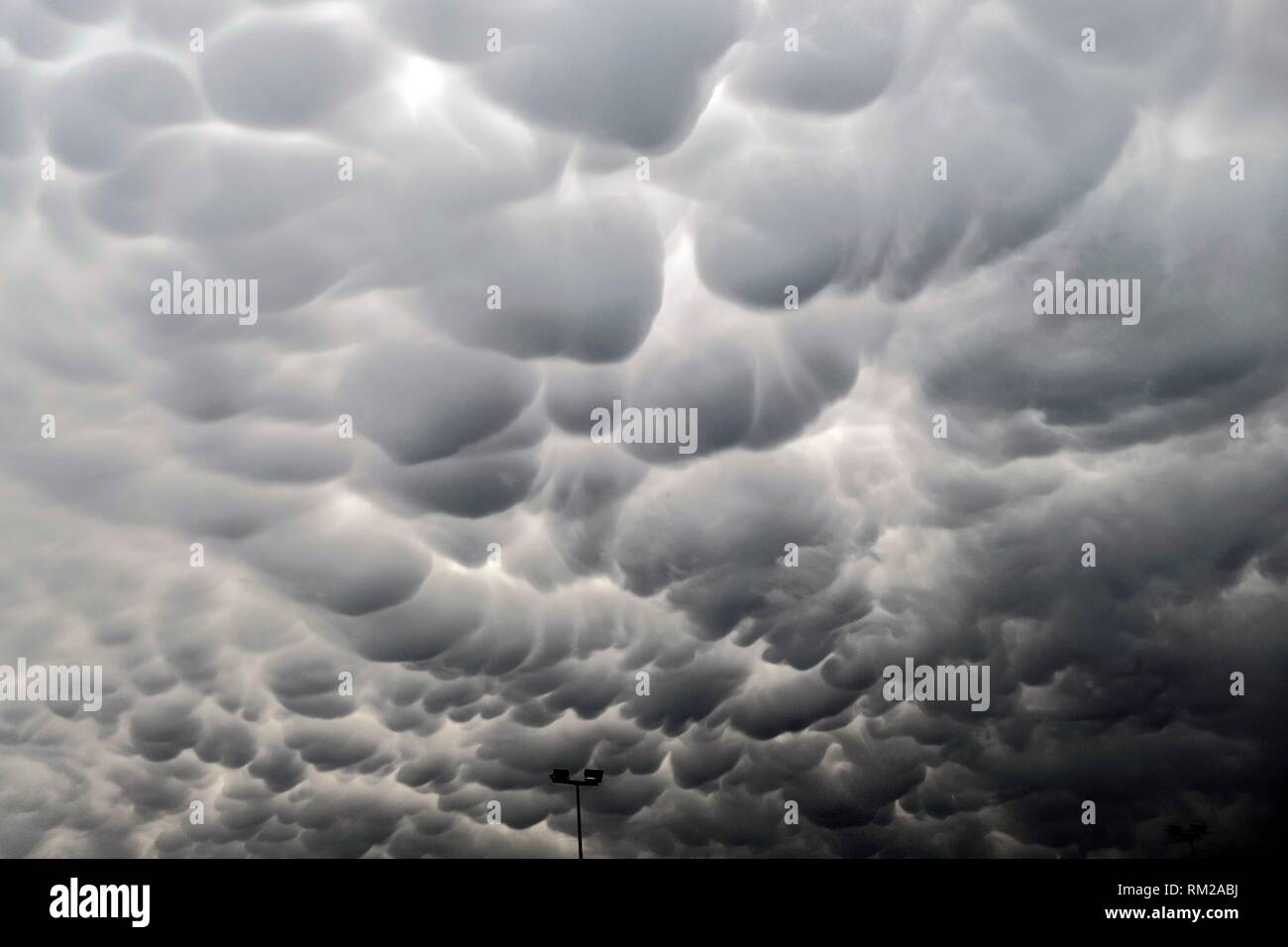 Ominous, billowing cloud formation and street lighting, Department du Nord, France. Stock Photo