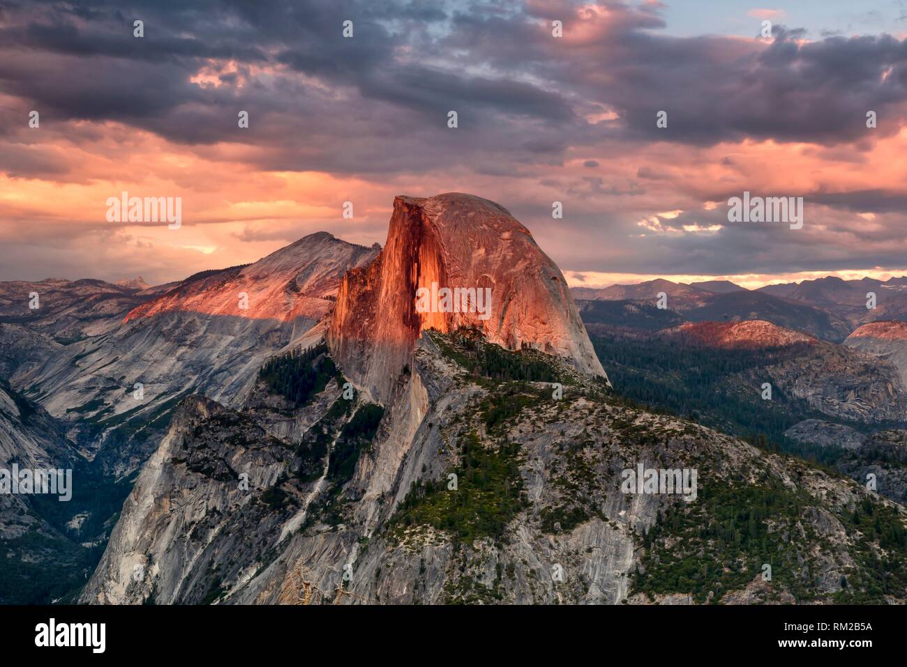 Vivid summer storm clouds at sunset above Half Dome and Glacier Point in Yosemite National Park, USA. Stock Photo