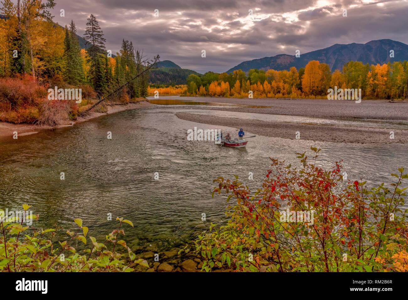 Fall Fly Fisherman in Float Boat on North Fork Flathead River Glacier National Park Montana USA. Stock Photo