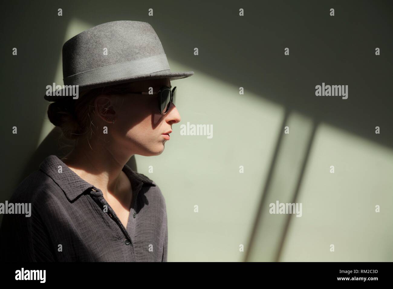 Young serious woman wearing a hat and sunglasses. Stock Photo