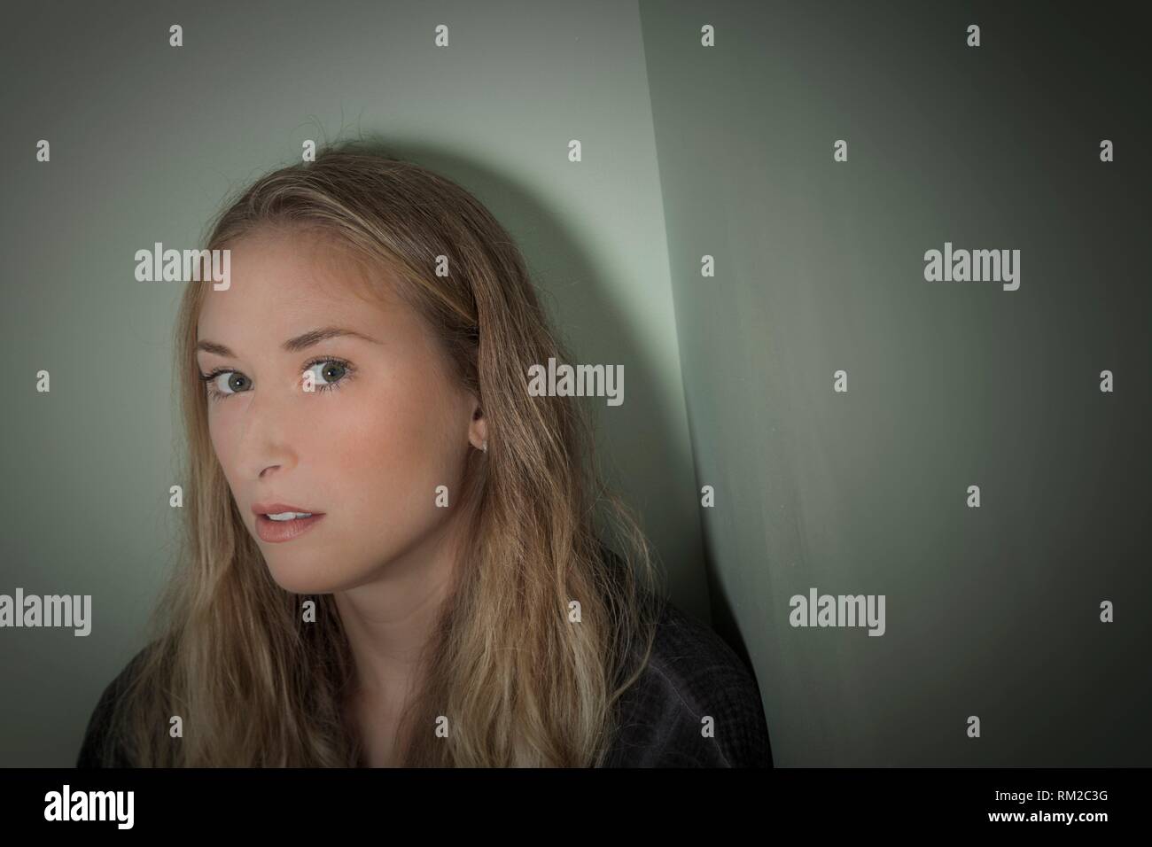 Young mysterious blonde woman looking into the camera. Stock Photo