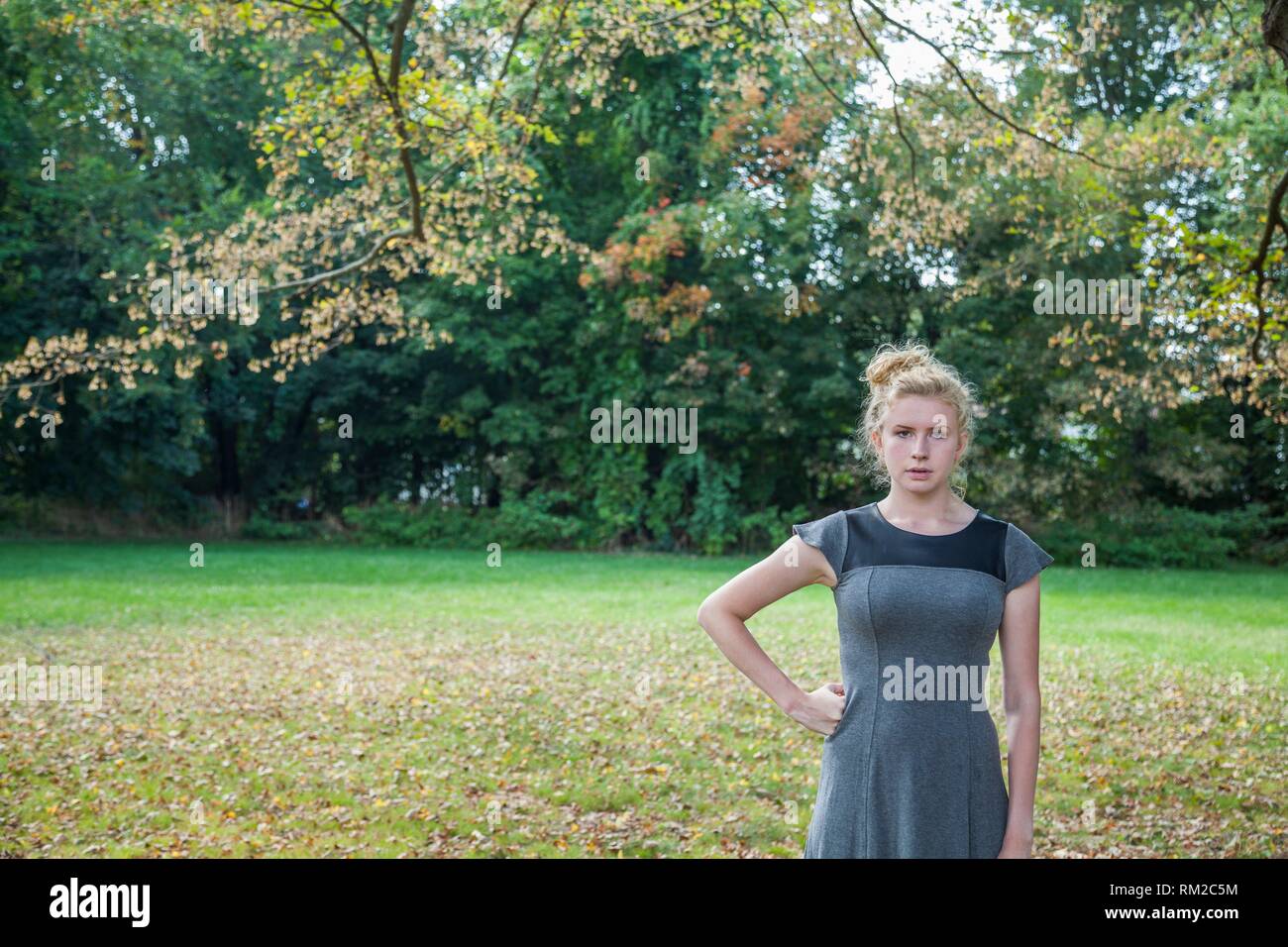 Blonde teenage girl standing outdoors. Stock Photo