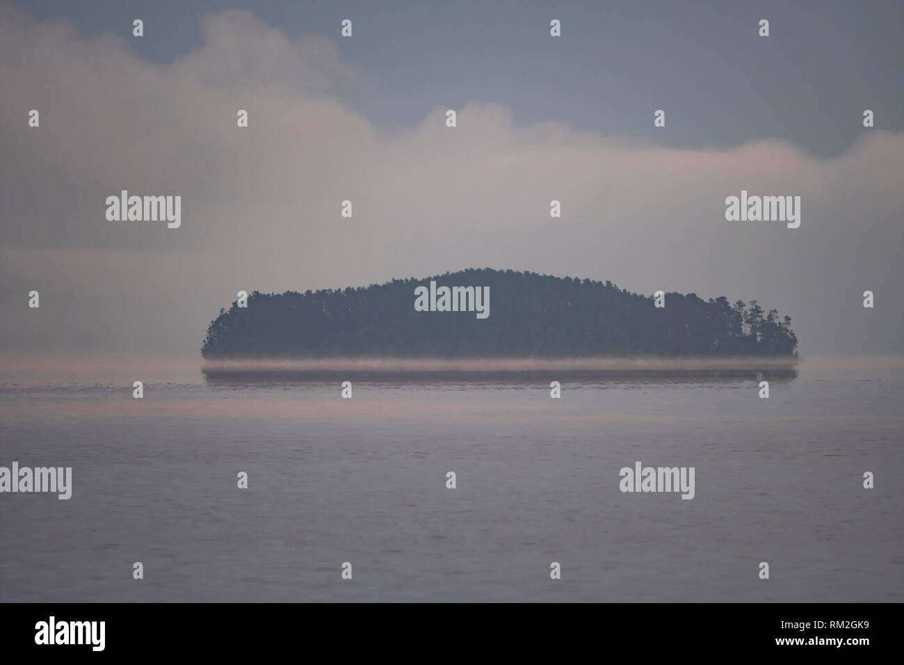 Island Appearing out of the Morning Fog on Saganaga Lake in Quetico Provincial Park in Ontario Stock Photo