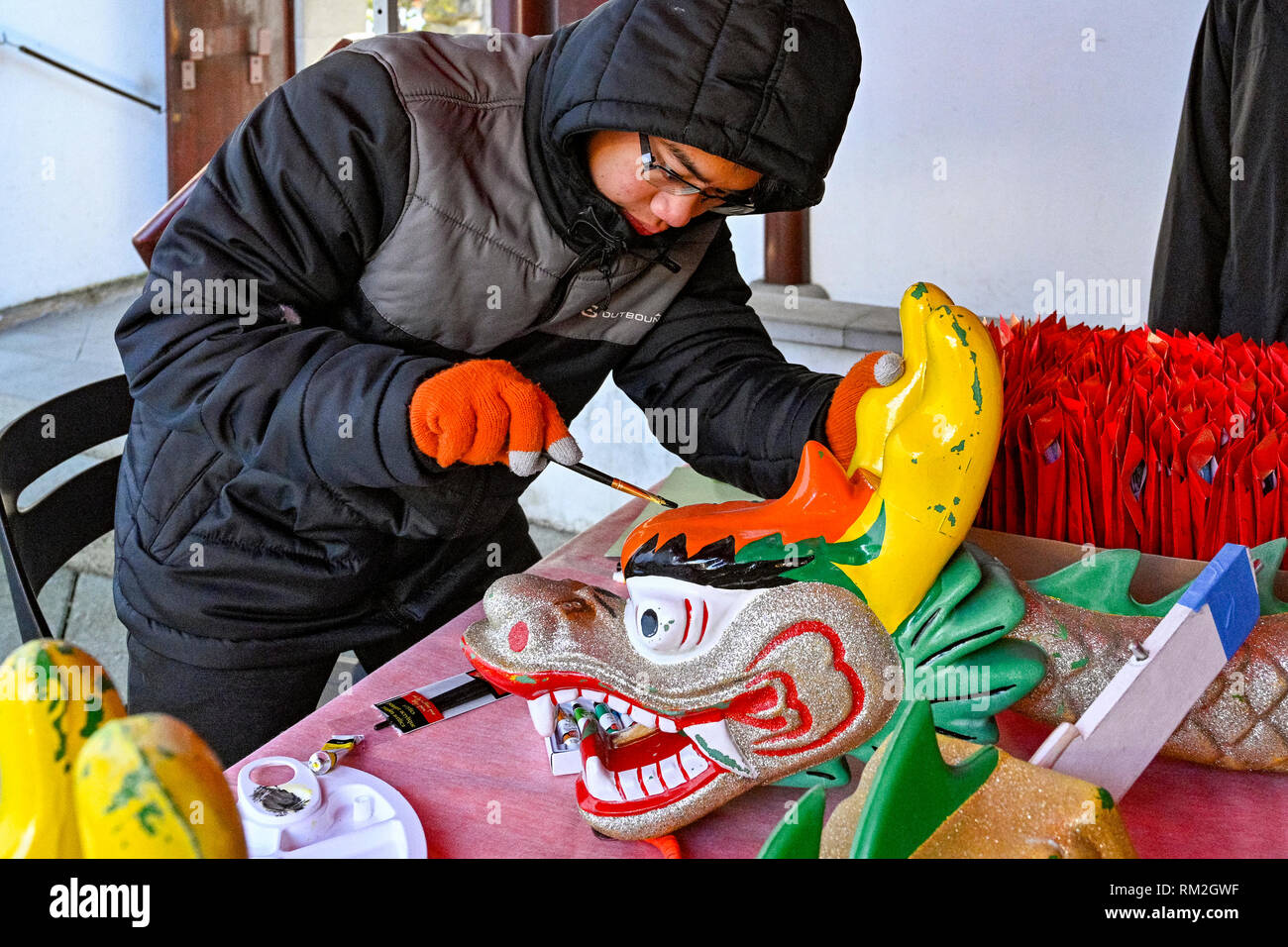 Young man painting Dragon Boat figurehead, Dr Sun Yat Sen Park and Classical Chinese Garden, Vancouver, British Columbia, Canada Stock Photo