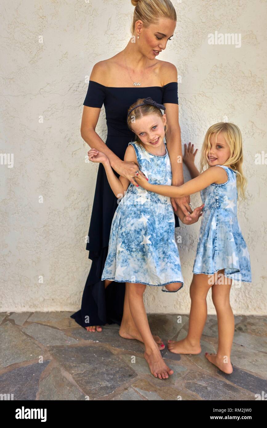 candid family, mother with two daughters enjoying togetherness in front